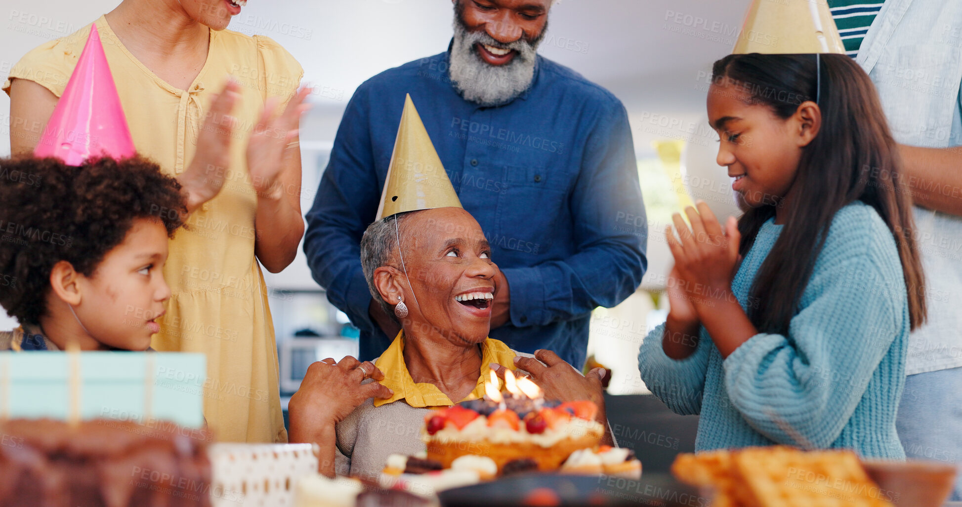 Buy stock photo Cake, happy and family at birthday party celebration together at modern house with candles. Smile, excited and young children with African father and grandparents with hat for sweet dessert at home.