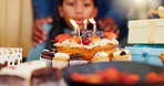 Happy birthday, cake and candle light in celebration with family for party, holiday or special day at home. Excited little girl or child blowing for wish in growth, love or care and bonding at house