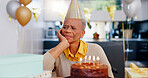 Sad, birthday and senior woman thinking with depression, grief and lonely in her home. Cake, face and elderly African person alone at a party with disappointment, frustrated or annoyed in a house