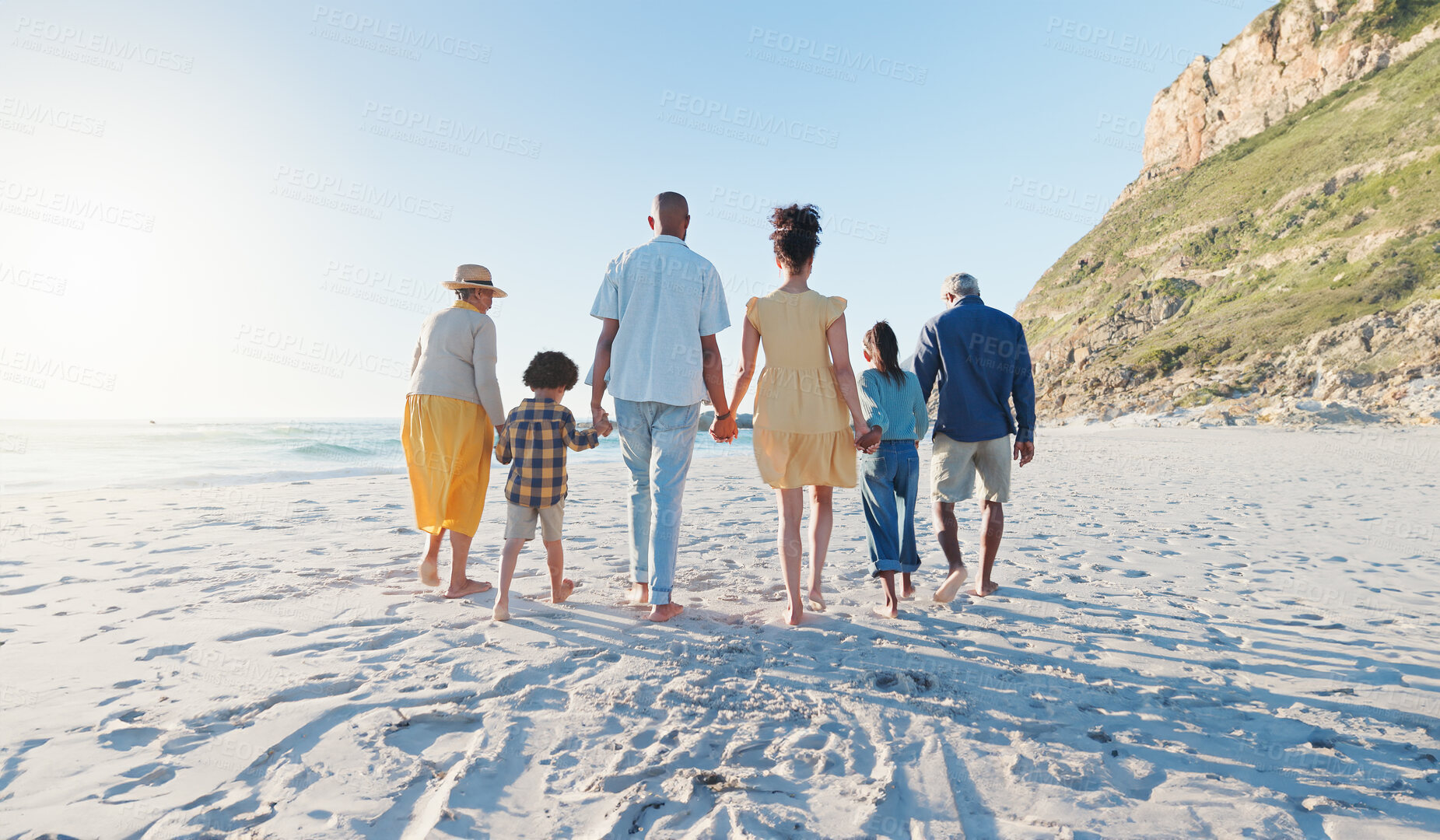 Buy stock photo Holding hands, walking and big family at the beach on holiday, adventure or vacation together. Love, travel and children with parents and grandparents on the sand by the ocean or sea on weekend trip.