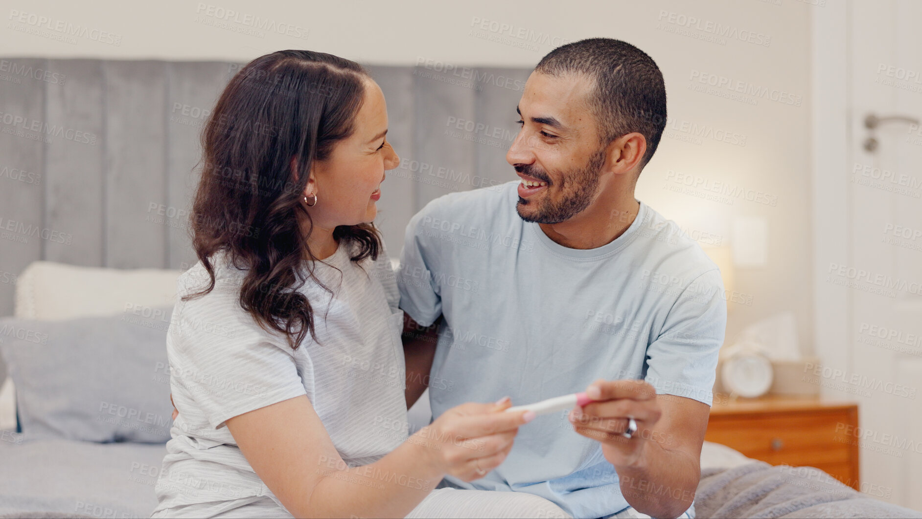 Buy stock photo Excited couple, bed and positive pregnancy test for family, start or maternity at home. Face of happy man and pregnant woman smile for parenthood, morning or good news or results in bedroom together