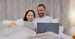 Tablet, laptop and young couple in bed watching movie and networking on social media at home. Smile, bonding and man and woman relaxing in bedroom with digital technology and computer at modern house