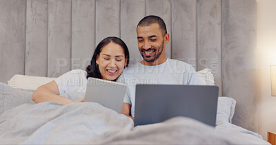 Buy stock photo Tablet, laptop and young couple in bed watching movie and networking on social media at home. Smile, bonding and man and woman relaxing in bedroom with digital technology and computer at modern house
