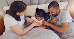 Happy, tickling and parents with child in bed on a weekend morning in modern family home. Laughing, fun and young mother and father bonding, relaxing and playing with girl kid in bedroom at house.