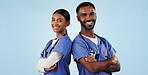 Portrait, healthcare and arms crossed with a medicine team in studio on a blue background for trust. Medical, smile or wellness with a young man and woman nurse looking confident for treatment