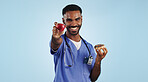 Happy man, doctor and apple with donut for diet or healthy eating against a blue studio background. Portrait of male person or medical nurse smile with organic fruit and chocolate dessert for choice