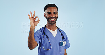 Buy stock photo Happy man, okay or portrait of doctor with smile, pride or confidence isolated on blue background. Wellness, perfect or healthcare worker with approval sign, success or yes hand gesture in studio