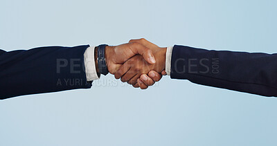 Buy stock photo Business people, handshake and meeting for partnership, deal or agreement against a blue studio background. Closeup of employees shaking hands for b2b, introduction or thank you on mockup space