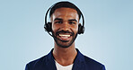 Happy man, portrait and headphones for call center or telemarketing against a blue studio background. Face of friendly male person, consultant or agent smile with mic in online advice on mockup space