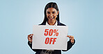 Happy woman, portrait and sign for advertising discount, deal or half price against a blue studio background. Female person with billboard or poster in marketing, promotion or special on mockup space