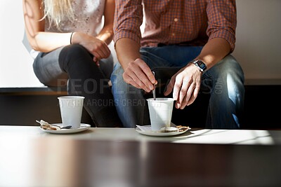 Buy stock photo Cropped image of a young couple enjoying coffee at their local cafe