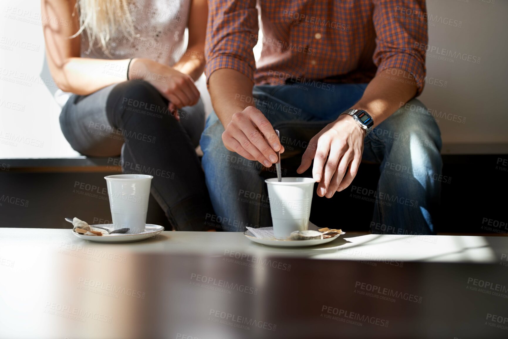 Buy stock photo Cropped image of a young couple enjoying coffee at their local cafe