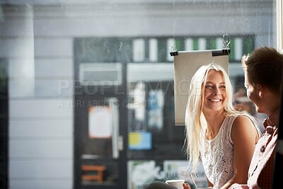 Buy stock photo A young couple having a fun date in a coffee shop