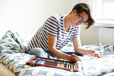Buy stock photo Creative, artist and man sketch in bedroom with color, pencils or college student studying art in home. Drawing, hobby and person with inspiration to design, ideas or process of creativity in house