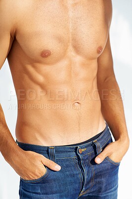 Buy stock photo Relax, body and jeans with a man in studio isolated on a white background closeup for masculine style. Fashion, muscle or macho and a cool, shirtless person in denim with his hands in his pockets