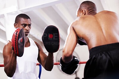 Buy stock photo Black man, boxer and personal trainer in self defense or ring fight at gym workout, exercise or training together. African male person with boxing or sparing partner preparing for sports competition