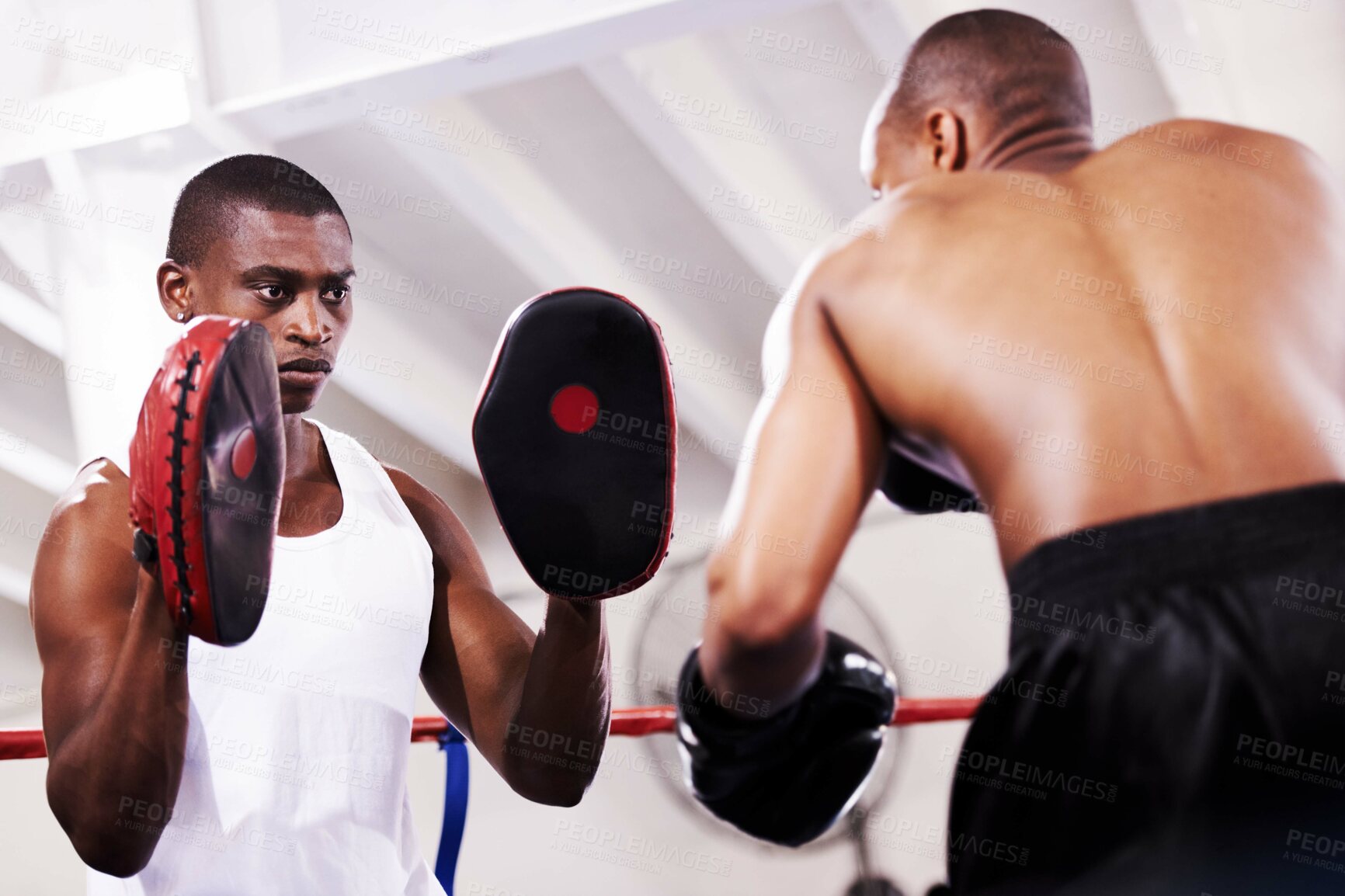 Buy stock photo Black man, boxer and personal trainer in self defense or ring fight at gym workout, exercise or training together. African male person with boxing or sparing partner preparing for sports competition