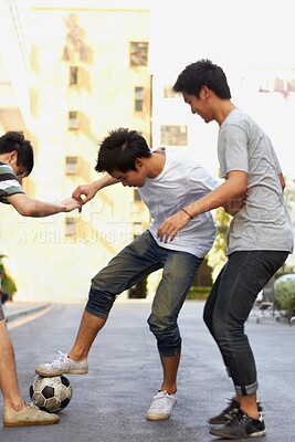 Buy stock photo Friends in city street playing soccer together for sports, fun and happy energy with urban games in Korea. Ball game for teen friendship, group of people in road with football, weekend in community.