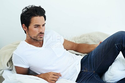 Buy stock photo Fashion, relax or casual with a sexy man in studio wearing jeans and a t-shirt while lying on the floor. Idea, lifestyle and natural with a handsome young male model thinking while relaxing at home
