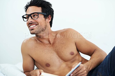 Buy stock photo Book, happy shirtless young man with glasses and on a bed in white background. Nerd or smart, male model with sexy body and smiling person topless in his home or apartment with notebook for reading