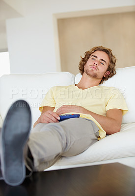 Buy stock photo Bored man, remote control and watching tv on sofa with bad mood, chilling on streaming service in his home. Depression, lonely and sad male person in a living room with television, cable or movies