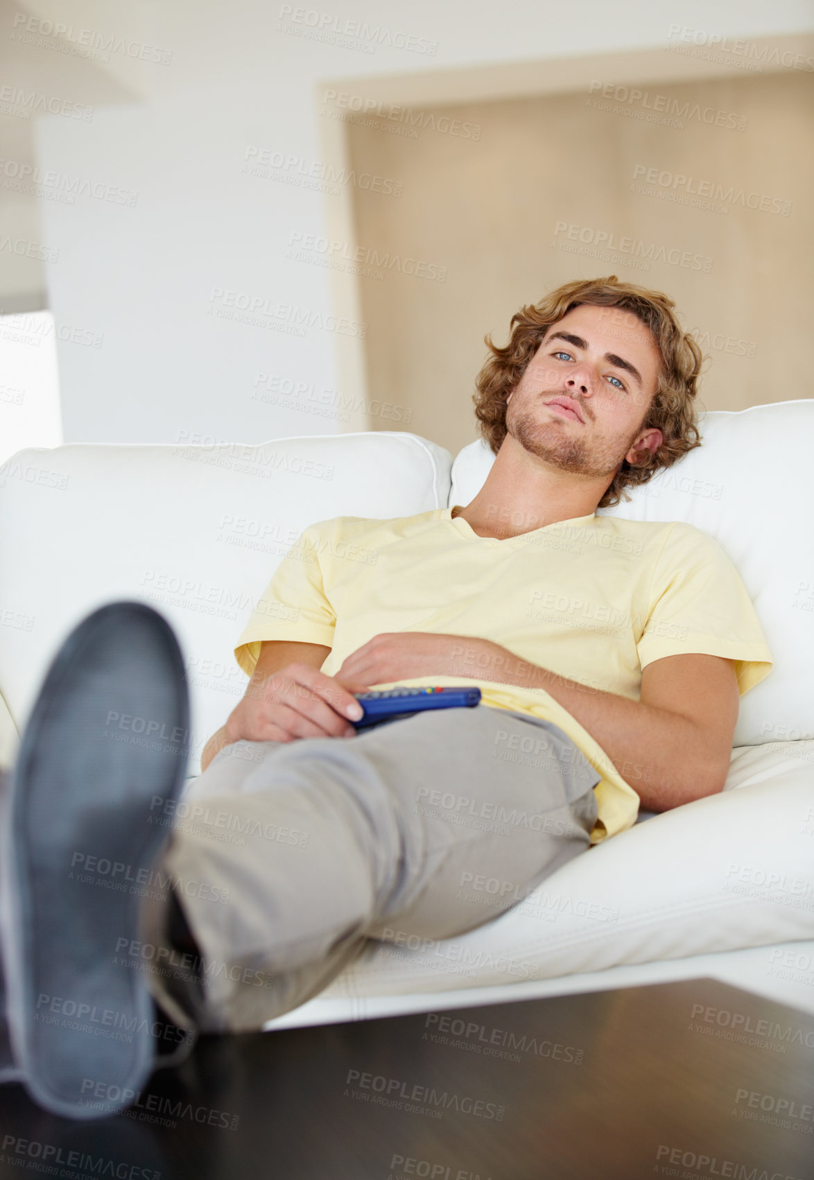 Buy stock photo Bored man, remote control and watching tv on sofa with bad mood, chilling on streaming service in his home. Depression, lonely and sad male person in a living room with television, cable or movies