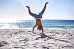 Cartwheel, happy and child on beach for fun, playing and relax on holiday, vacation and weekend. Travel, nature and young African boy do handstand on sand for freedom, adventure and enjoy childhood
