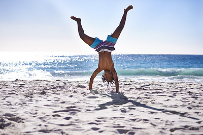 Buy stock photo Cartwheel, happy and child on beach for fun, playing and relax on holiday, vacation and weekend. Travel, nature and young African boy do handstand on sand for freedom, adventure and enjoy childhood