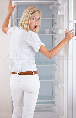 Buy stock photo Woman, portrait and surprise with empty fridge in debt, financial crisis or stress in kitchen at home. Surprised or shocked young female person or blonde in bankruptcy, poverty or poor refrigerator