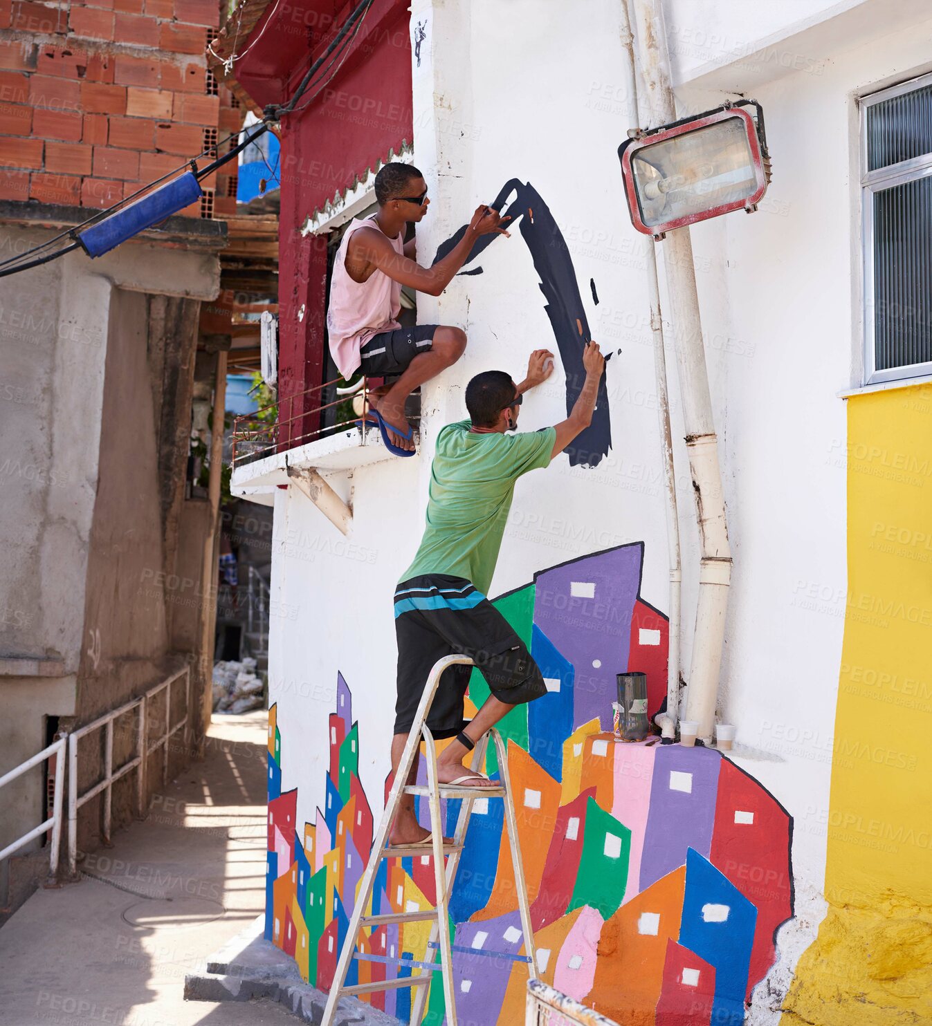 Buy stock photo Shot of two young graffiti artists painting a design on a wall