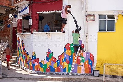 Buy stock photo Shot of two young graffiti artists painting a design on a wall