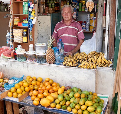 Buy stock photo Portrait of a street vendor selling a variety of food at his stall