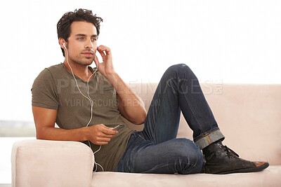 Buy stock photo Man, player or earphones on sofa and music, podcast or radio streaming for break in living room of home. Person, face or listening with technology on couch in lounge for sound, song or audio in house
