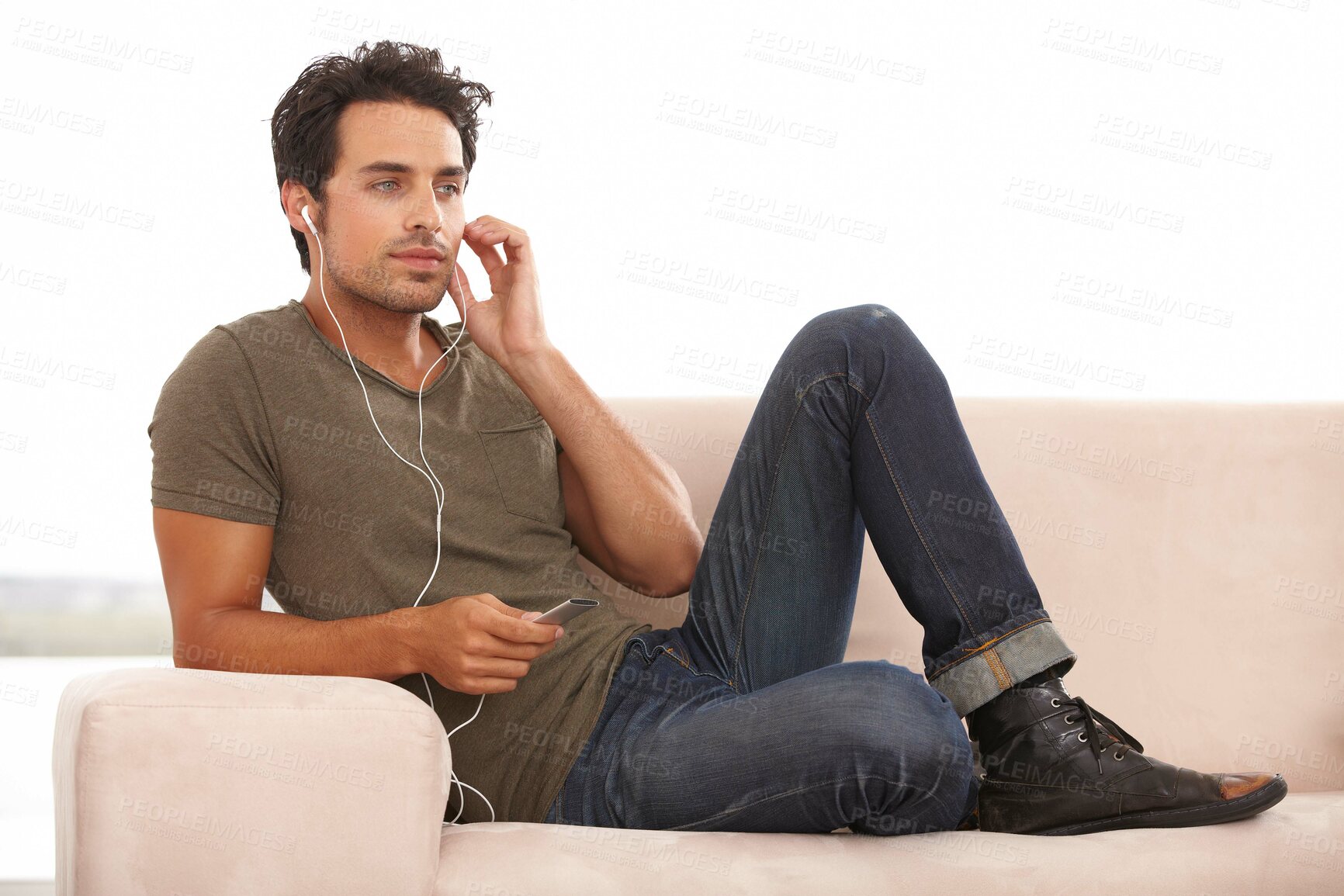 Buy stock photo Man, player or earphones on sofa and music, podcast or radio streaming for break in living room of home. Person, face or listening with technology on couch in lounge for sound, song or audio in house