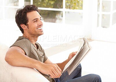 Buy stock photo Man, face and happy with newspaper on sofa for relax, morning break and information in living room. Person, excited and smile for article, story and news on couch of apartment for reading or peace  