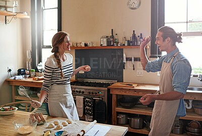 Buy stock photo Shot of a young couple making small balls of dough