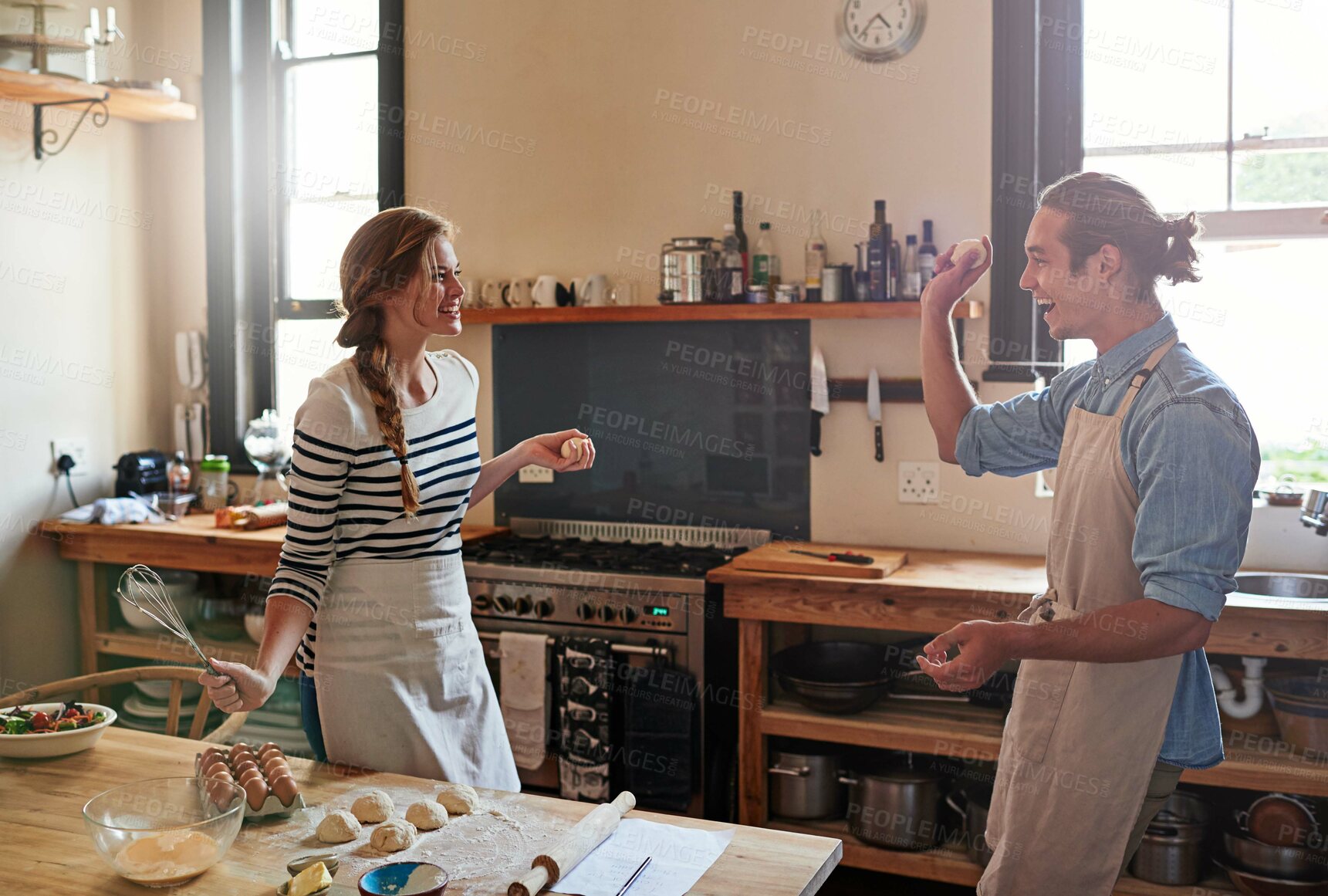 Buy stock photo Shot of a young couple making small balls of dough