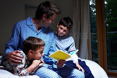 Buy stock photo A father reading to his two sons at bedtime - Copyspace