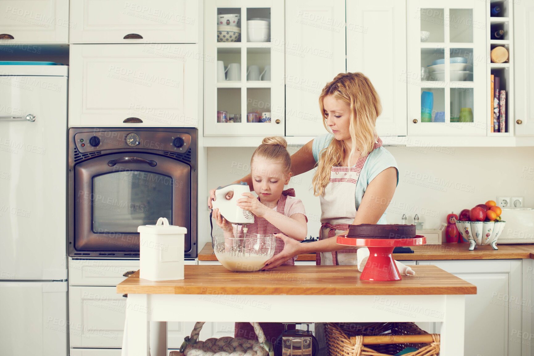 Buy stock photo Cute little girl baking in the kitchen at home with her mom