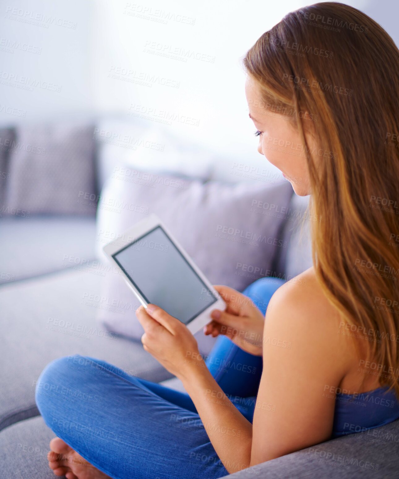 Buy stock photo Shot of a young woman using a digital tablet at home