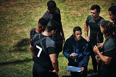 Buy stock photo Cropped shot of a handsome young rugby coach addressing his team on the field during the day