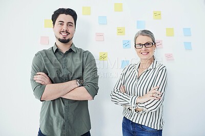 Buy stock photo Portrait of two businesspeople standing with their arms crossed against a wall with notes in an office