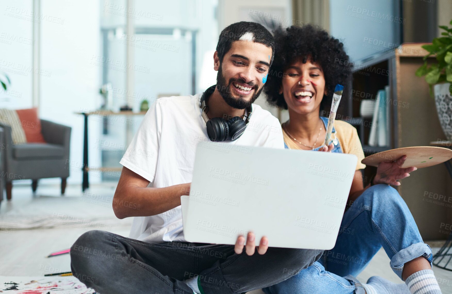 Buy stock photo Shot of a young couple using a laptop while painting at home