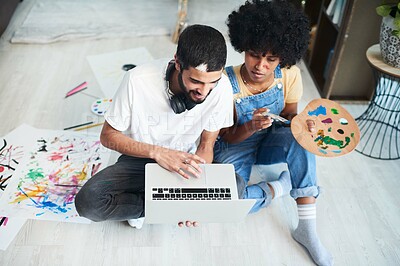 Buy stock photo Shot of a young couple using a laptop while painting at home