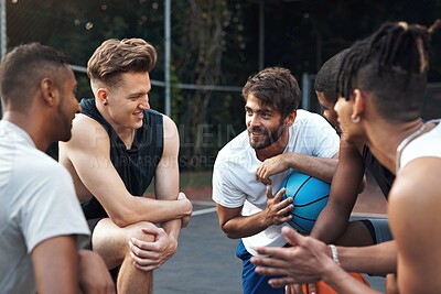 Buy stock photo Shot of a group of sporty young men chatting to each other on a basketball court