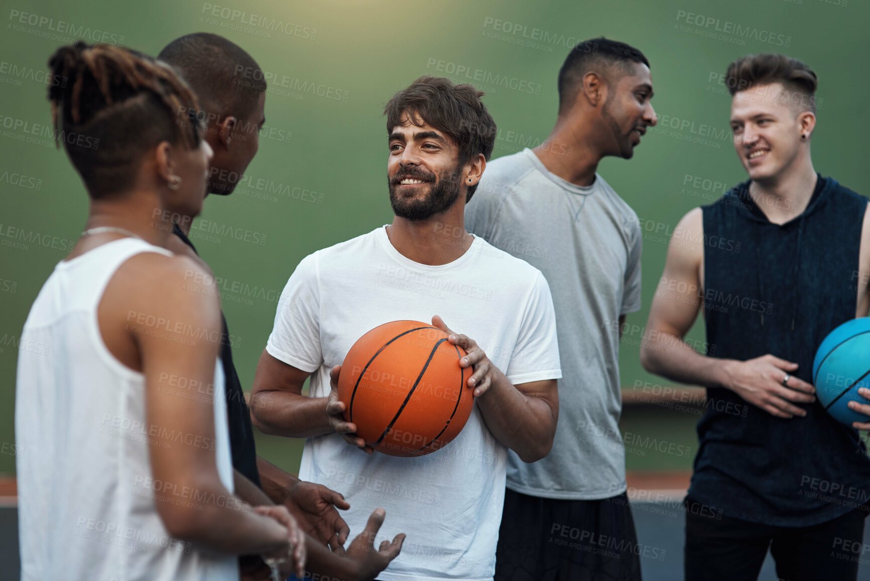 Buy stock photo Shot of a group of sporty young men hanging out on a basketball court