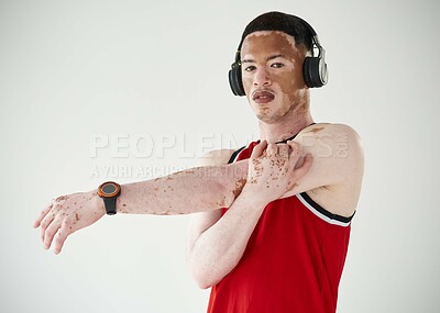 Buy stock photo Cropped portrait of a handsome young male basketball player stretching in studio