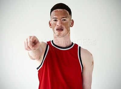 Buy stock photo Cropped portrait of a handsome young male basketball player pointing in studio