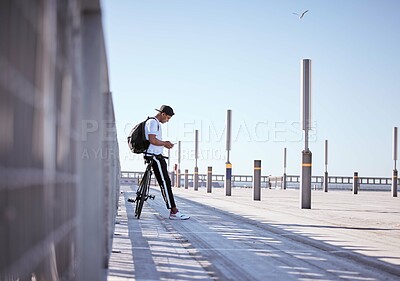Buy stock photo Shot of a young man posing in a parking lot on a sunny day.