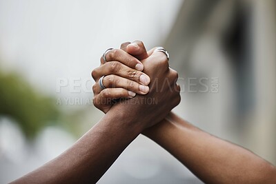 Buy stock photo Closeup shot of two unrecognizable male gangsters shaking hands outside on the street